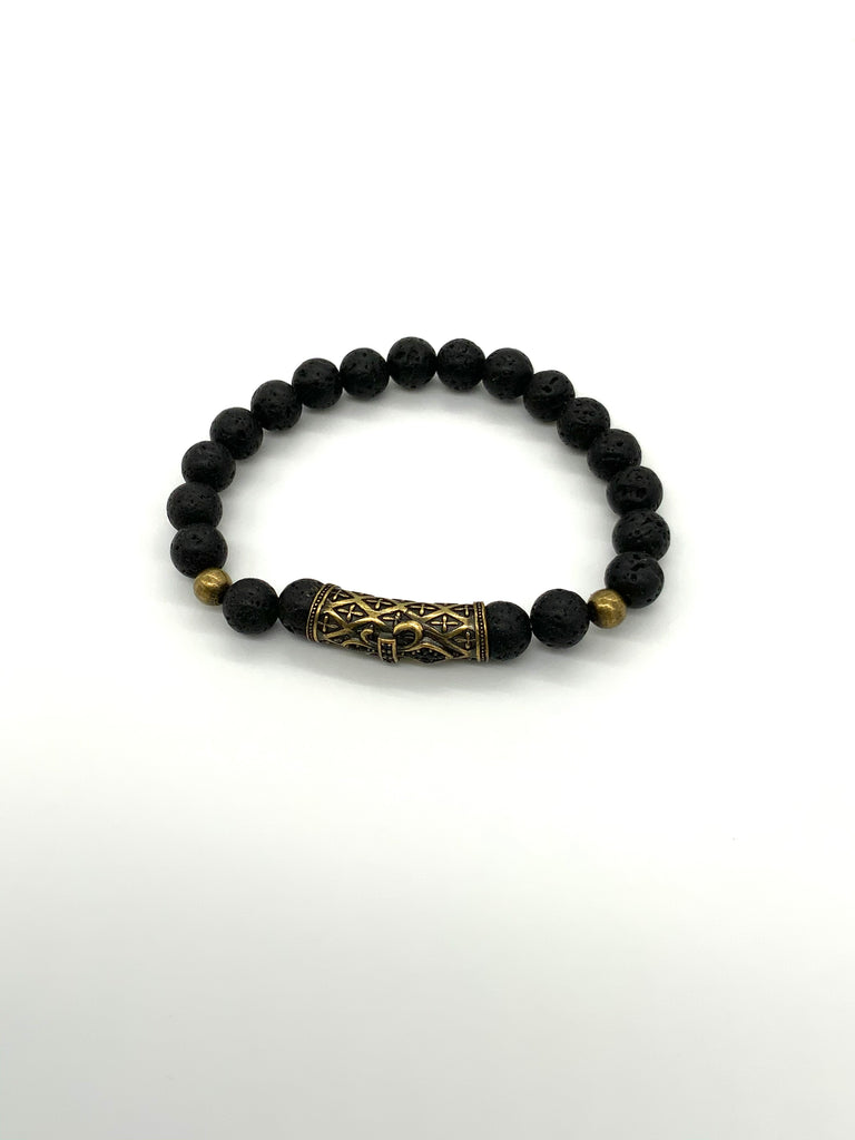Black lava rock bracelet with a large gold accent bead in front and 2 smaller accent beads on either side 
